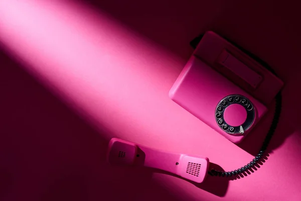 明るい表面に影とヴィンテージピンクの電話のトップビュー — ストック写真