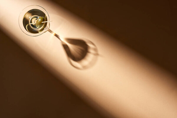 Top view of cocktail with olives on beige background