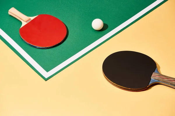 Zwei Tischtennisschläger Und Ball Auf Grüner Und Gelber Fläche Mit — Stockfoto