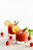 Bloody Mary koktejl v brýlích zdobené vápnem a celer izolované na bílém s rajčaty