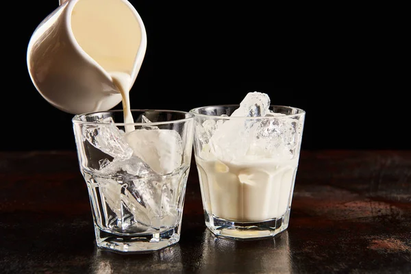 Milch Glas Gießen Mit Eiswürfeln Isoliert Auf Schwarz — Stockfoto