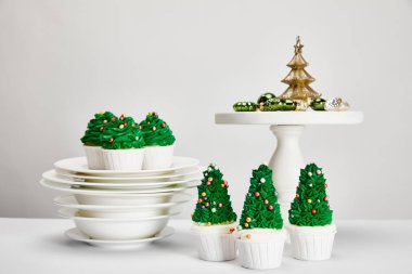Lezzetli Noel ağacı çörekleri tabakları ve parlak mücevherleri gri yüzeyde izole edilmiş.
