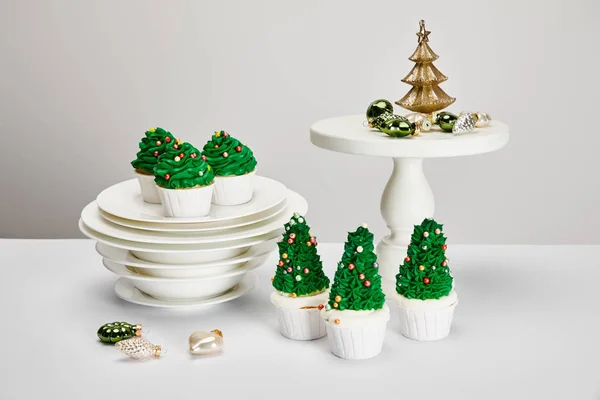 Heerlijke Kerstboom Cupcakes Met Borden Glanzende Kerstballen Wit Oppervlak Geïsoleerd — Stockfoto