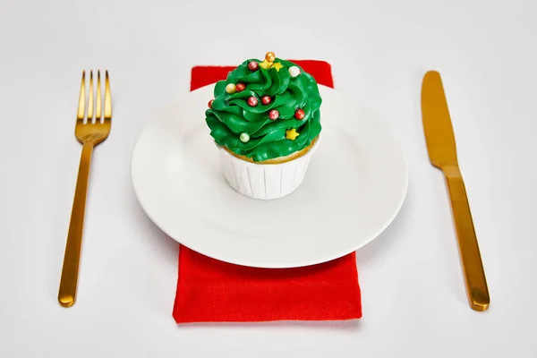 Delicioso Cupcake Plato Blanco Con Cubiertos Oro Servilleta Roja Superficie — Foto de Stock