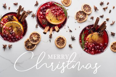 Portakal, nar ve noel resimli tarçınlı Noel kokteyllerinin en üst görüntüsü. 