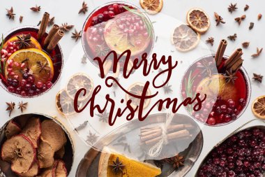 Portakal, nar, tarçın, tepside turta, kuru elma ve yılbaşı resimli donmuş yaban mersinli Noel kokteyllerinin en üst görüntüsü. 