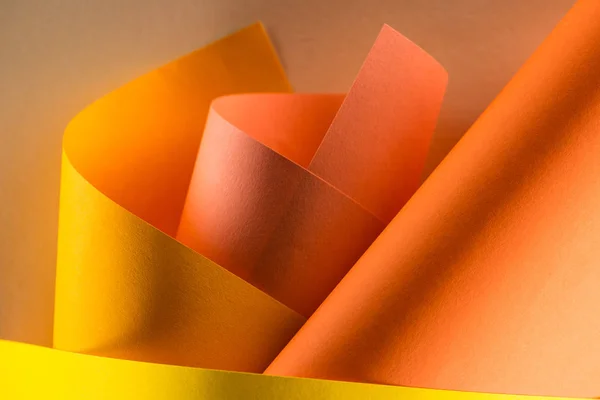 Primer plano plano de papeles de color naranja y amarillo enrollados para el fondo - foto de stock