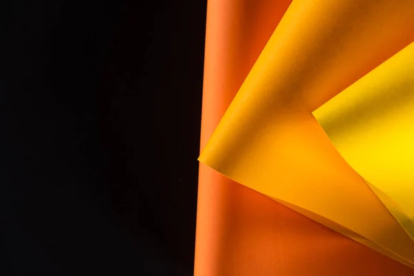 Orangefarbene und gelbe Papiere isoliert auf schwarz — Stockfoto
