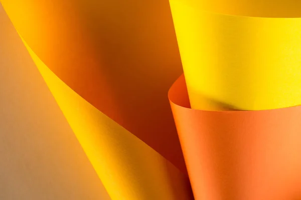 Close-up de papel laranja e amarelo rolado para fundo — Fotografia de Stock