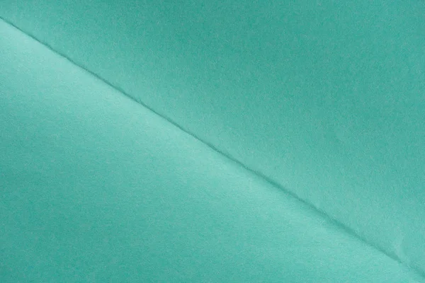 Close-up shot of turquoise color folded paper for background — Stock Photo