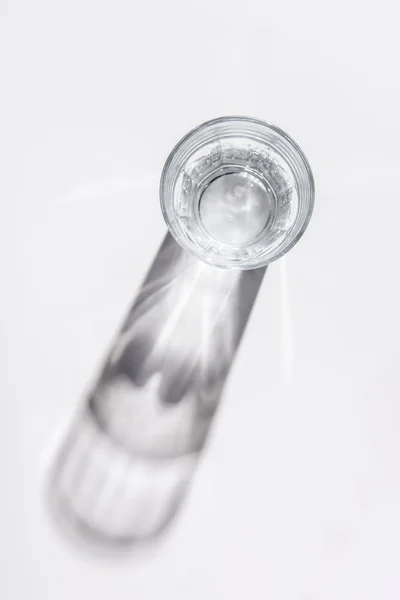 Vue de dessus du verre avec de l'eau sur la table blanche — Photo de stock