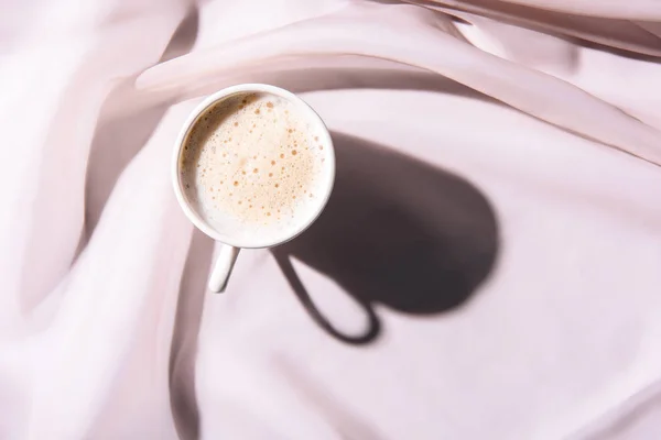 Vista superior da xícara de café na toalha de mesa rosa — Fotografia de Stock