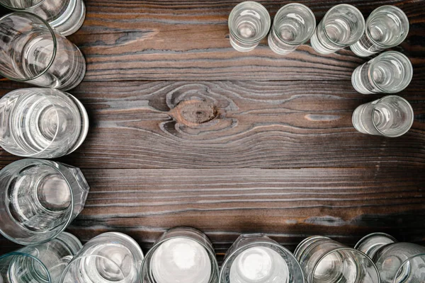 Vista superior de copos de diferentes tamanhos com água na mesa de madeira — Fotografia de Stock