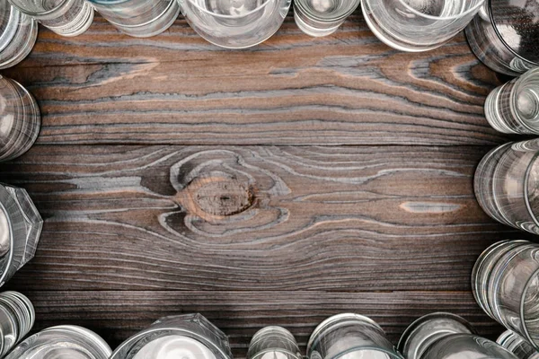 Vue de dessus du cadre avec des verres d'eau sur une table en bois — Photo de stock