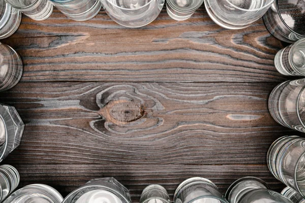 Top view of frame with glasses of water on wooden table — Stock Photo