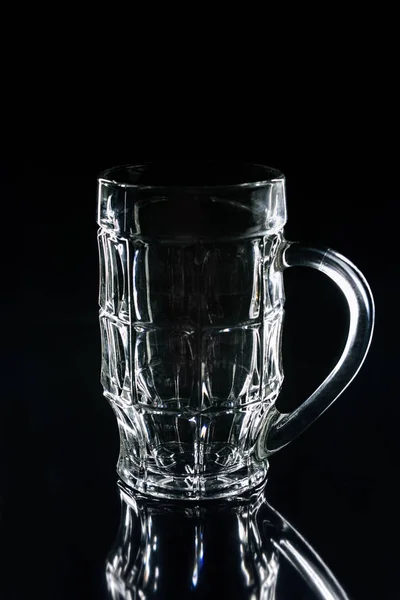 Un vaso de cerveza en la superficie reflectante negro - foto de stock