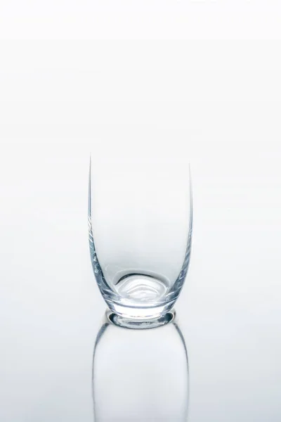 Un vaso sobre mesa reflectante blanca - foto de stock