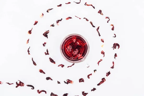 Vue du dessus de tasse avec thé hibiscus en spirale isolé sur blanc — Photo de stock