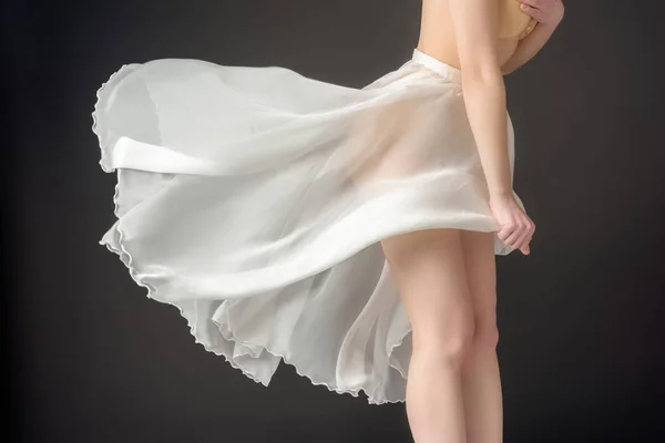 Cropped view of elegant girl in waving chiffon skirt, isolated on grey — Stock Photo