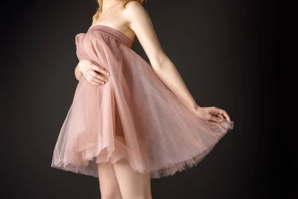 Средний вид нежной девушки, позирующей в розовом шифоновом платье, изолированном на сером — стоковое фото