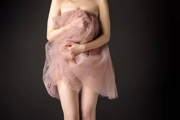 Частичный вид чувственной девушки, позирующей в розовом шифонном платье, изолированной на сером — стоковое фото