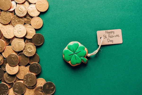 Draufsicht auf Sahnehäubchen in Form von Shamrock und Goldmünzen auf grünem, st patricks day concept — Stockfoto