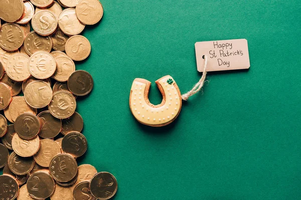 Top view of icing cookie in shape of horseshoe and golden coins on green, st patricks day concept — Stock Photo