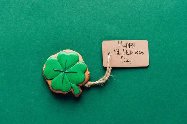 Top view of icing cookie in shape of shamrock on green, st patricks day concept — Stock Photo
