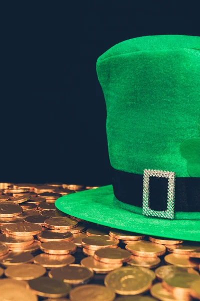 Chapéu verde em moedas douradas brilhantes isoladas em preto, st patricks conceito dia — Fotografia de Stock