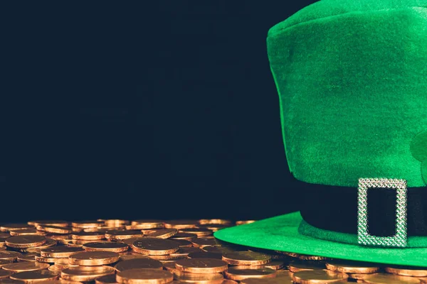 Green hat on golden coins isolated on black, st patricks day concept — Stock Photo