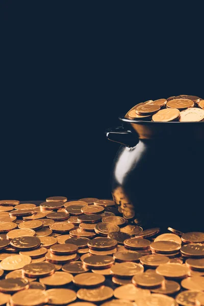 Black pot with shining golden coins isolated on black, st patricks day concept — Stock Photo