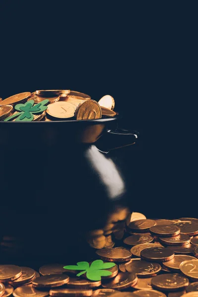 Pote preto com moedas de ouro na superfície isolada em preto, st patricks conceito dia — Fotografia de Stock