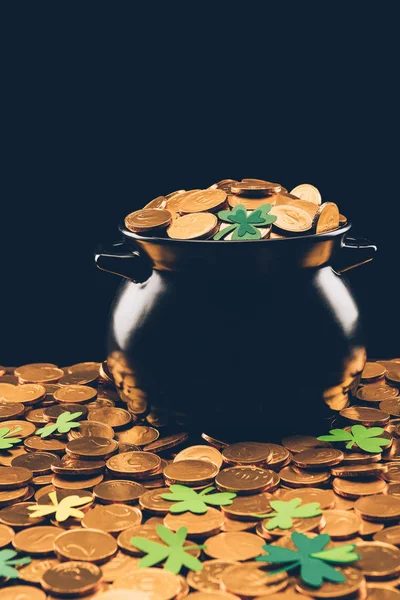 Black pot with golden coins isolated on black, st patricks day concept — Stock Photo