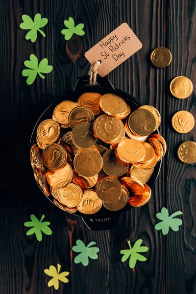 Top view of pot with golden coins and shamrock on wooden table, st patricks day concept — Stock Photo