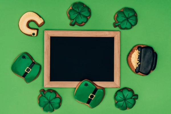 Top view of empty board with icing cookies isolated on green, st patricks day concept — Stock Photo