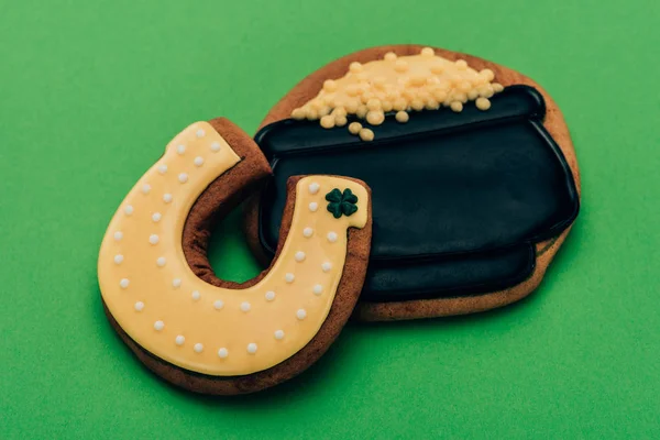 Visão de alto ângulo de gelo biscoitos em forma de ferradura e pote com moedas em verde, st patricks conceito dia — Fotografia de Stock