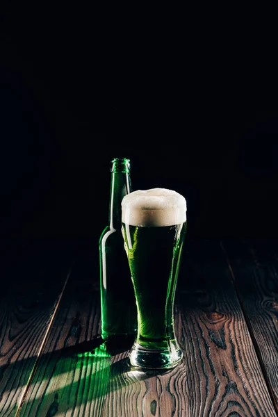 Brilhante vidro e garrafa de cerveja verde na mesa de madeira, st patricks conceito dia — Fotografia de Stock