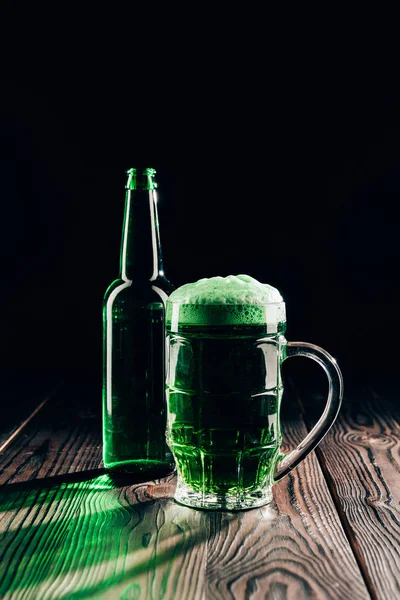 Glas und Flasche Grünbier auf Holztischplatte, st patricks day concept — Stockfoto