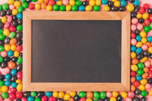 Blick von oben auf leere Tafel und bunte Bonbons — Stockfoto