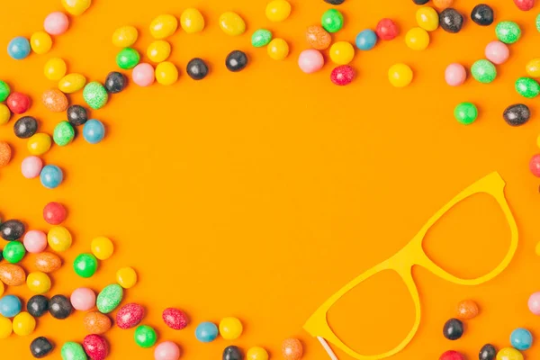 Top view of party mask and sweets isolated on orange, purim holiday concept — Stock Photo