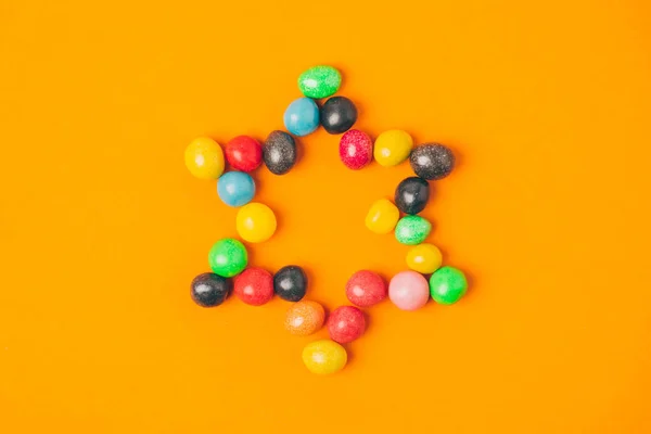 Vista superior de la estrella hecha de dulces aislados en naranja, concepto de vacaciones purim - foto de stock