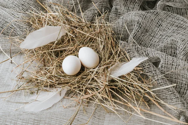 Uova bianche che depongono sulla paglia sopra un sacco — Foto stock