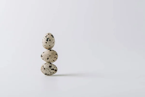 Quail eggs stacked on white background — Stock Photo