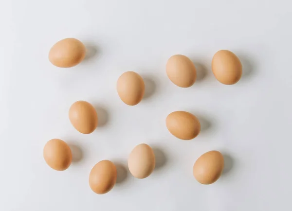 Коричневі яйця розкидані на білому тлі — стокове фото
