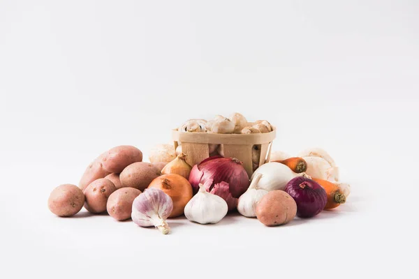 Monte de cogumelos que colocam na cesta sobre legumes no fundo branco — Fotografia de Stock