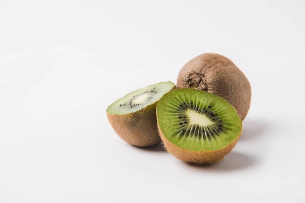 Whole and halved kiwi laying on white background — Stock Photo