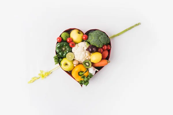 Vegetables and fruits laying in heart shaped dish isolated on white background — Stock Photo