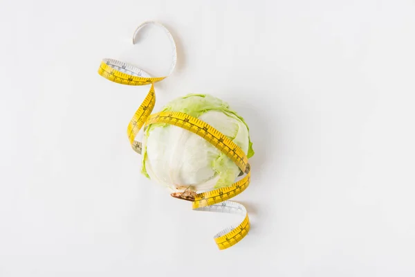 Сырой зеленый круглый салат с измерительной лентой на белом фоне — стоковое фото