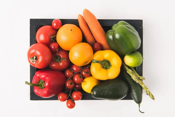 Вид зверху на барвисті овочі та фрукти в темній дерев'яній коробці ізольовані на білому тлі — стокове фото