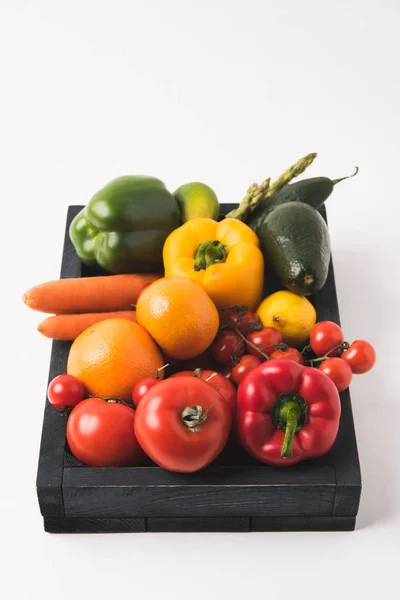 Rohes, buntes Gemüse und Obst in dunkler Holzkiste isoliert auf weißem Hintergrund — Stockfoto